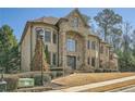 Beautiful stone and brick house with manicured lawn and mature trees in a suburban neighborhood at 2015 Shaudi Ln, Atlanta, GA 30345