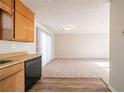 Open kitchen with wood cabinets and breakfast area with carpet at 3332 Fannin Ct, Lithonia, GA 30038