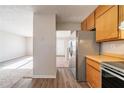 Bright kitchen with stainless steel fridge, wood cabinets, and laminate flooring at 3332 Fannin Ct, Lithonia, GA 30038