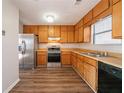 Functional kitchen with stainless steel appliances, wood cabinets, and laminate flooring at 3332 Fannin Ct, Lithonia, GA 30038