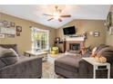 A well-lit living room offers comfortable seating, a fireplace, and a ceiling fan at 34 Clay Ct, Villa Rica, GA 30180