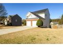 Exterior view of the home with a two-car garage and driveway at 1188 Pine Acre Dr, Sugar Hill, GA 30518