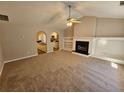 Cozy living room featuring a fireplace, neutral walls, and a ceiling fan at 6531 Gina Agha Cir, Lithonia, GA 30038