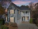 Two-story house with gray siding, a two-car garage, and a landscaped yard, at dusk at 589 Lantern Wood Dr, Scottdale, GA 30079