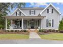 Gray farmhouse exterior with a wraparound porch and landscaping at 527 Main St, Suwanee, GA 30024