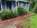 Front of the home with blue shutters surrounded by landscaping and foliage at 3530 Fairlane Nw Dr, Atlanta, GA 30331