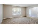 Living room with neutral walls, carpeted floors, and two windows at 3100 Aberdeen Way, Lithonia, GA 30038