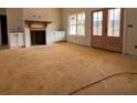 An unfinished living room featuring a fireplace, built-in cabinets, and double doors to the outside at 431 Barnwood Dr, Rockmart, GA 30153