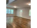 Bright living room featuring stylish wood floors, neutral walls, and ample natural light from large windows at 2467 Shady Grove Rd, Carrollton, GA 30116