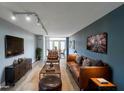 Staged living room featuring modern lighting, a stylish leather sofa, and a mounted TV at 375 Ralph Mcgill Blvd # 603, Atlanta, GA 30312