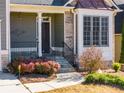 Inviting front porch features stone accents, pendant lighting, and beautiful landscaping at 243 Yorkshire Ln, Villa Rica, GA 30180