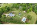 Aerial view of property featuring a pool, solar building, and lush green landscape at 289 Barn Rd, Canton, GA 30115