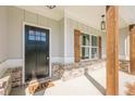 Inviting front porch with rustic wood supports, brick accents, and a charming 'hello' welcome mat at 30 Pinewood Dr, Covington, GA 30014