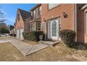 Inviting entrance to this lovely brick home, featuring a decorative pot and manicured bushes at 6849 Fireside Ln, Atlanta, GA 30349
