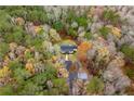 Aerial view of home nestled among the trees with a long driveway and small outbuilding at 3465 Callie Still Rd, Lawrenceville, GA 30045