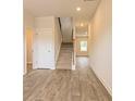 Hallway view featuring the stairway with carpeted steps and wood-look flooring, bright lighting, and neutral walls at 305 Bianca Way, Mcdonough, GA 30253
