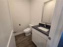Powder room featuring a granite countertop vanity and modern toilet at 1637 Fuma Leaf Way, Mcdonough, GA 30253