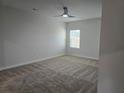 Spacious carpeted bedroom with modern ceiling fan, ample natural light, and neutral walls at 1637 Fuma Leaf Way, Mcdonough, GA 30253
