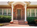Inviting front entrance with a brick facade, white pillars, and a stylish wooden door at 833 E Morningside Ne Dr, Atlanta, GA 30324