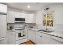 Bright kitchen featuring white cabinets, tiled backsplash, and modern appliances at 370 Charlyne Way, Dacula, GA 30019