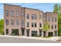 Stylish brick townhomes with dark-framed windows, blue doors, and manicured landscaping at 822 Urban Grange Way, Suwanee, GA 30024