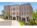 Charming townhome exterior featuring a brick facade, manicured landscaping, and a paved walkway at 923 Echo Park Dr, Suwanee, GA 30024