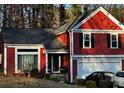 A vibrant red two-story home featuring a well-manicured lawn and two-car garage at 7472 Wood Ct, Lithonia, GA 30058