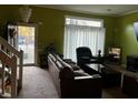 Comfortable living room featuring neutral carpet, a cozy leather sofa and a large window at 7472 Wood Ct, Lithonia, GA 30058