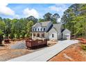 New construction home features a paved drive and an exterior with white siding and a front porch at 10350 Alvin Road, Alpharetta, GA 30022