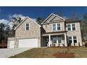 Attractive stone two-story home with a landscaped front yard, offering classic design elements at 6969 Melody Dr, Buford, GA 30518