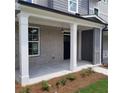 Spacious covered front porch with gray brick, white columns and a hanging lantern at 4107 Futral Way, Acworth, GA 30101