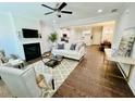 Open-concept living room with a fireplace, ceiling fan, and hardwood floors at 4107 Futral Way, Acworth, GA 30101