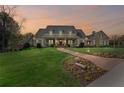 Stunning two-story home at sunset, with a manicured lawn and a charming brick walkway to the entrance at 710 Cox Rd, Roswell, GA 30075
