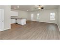 Open living area with kitchen island, wood-look floors, and ceiling fan at 527 Firethorn Ct, Villa Rica, GA 30180