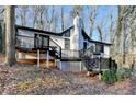Charming white house with black accents, deck, and stone chimney at 1695 Bull Sw Run, Lilburn, GA 30047