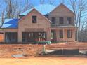 Two-story house under construction with a gable roof and large windows at 6949 Melody Dr, Buford, GA 30518