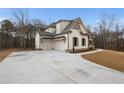 Home's exterior features a three-car garage and large driveway at 325 Mont Harmony Sw Rd, Powder Springs, GA 30127