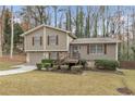 Two-story house with attached garage and deck, nestled in a wooded area at 1531 Harbour Oaks Rd, Tucker, GA 30084