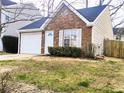 Brick and vinyl-sided home with a white garage door and landscaping at 1040 Hillsborough Chase Nw, Kennesaw, GA 30144