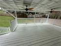 Covered deck boasts white railings and ceiling fans, offering a serene view of the backyard at 3967 Evelyn Dr, Powder Springs, GA 30127