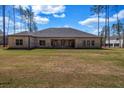 Expansive backyard view showcasing the home's brick exterior and covered patio at 125 Drummond Pl, Covington, GA 30014
