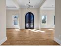 Elegant foyer featuring an ornate iron door, light hardwood flooring, and contemporary chandelier at 125 Drummond Pl, Covington, GA 30014
