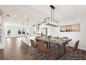 Bright dining area with modern chandelier, wood floors, and an open floor plan connecting to the kitchen at 434 Herring Dr, Acworth, GA 30102