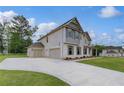 Side view of house, showcasing a three-car garage and ample parking space at 157 Haverling Pass, Hampton, GA 30228