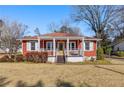 Red ranch style home with a covered porch and well-maintained lawn at 318 Stewart Nw Ave, Marietta, GA 30064