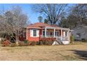 Charming red house with a front porch and landscaped yard at 318 Stewart Nw Ave, Marietta, GA 30064