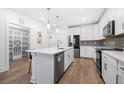 Well-lit kitchen with stainless steel appliances and ample counter space with view of pantry and front entrance at 3211 Orwell Way # 4302, Cumming, GA 30041