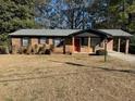 Brick ranch house with a carport and well-maintained lawn at 5380 Saint Lo Ln, Atlanta, GA 30349