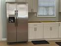 Modern kitchen featuring stainless steel refrigerator and white cabinets at 5380 Saint Lo Ln, Atlanta, GA 30349