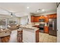 Modern kitchen with stainless appliances, granite counters, tile backsplash, and a breakfast bar overlooking the living room at 241 Kigian Trl, Woodstock, GA 30188